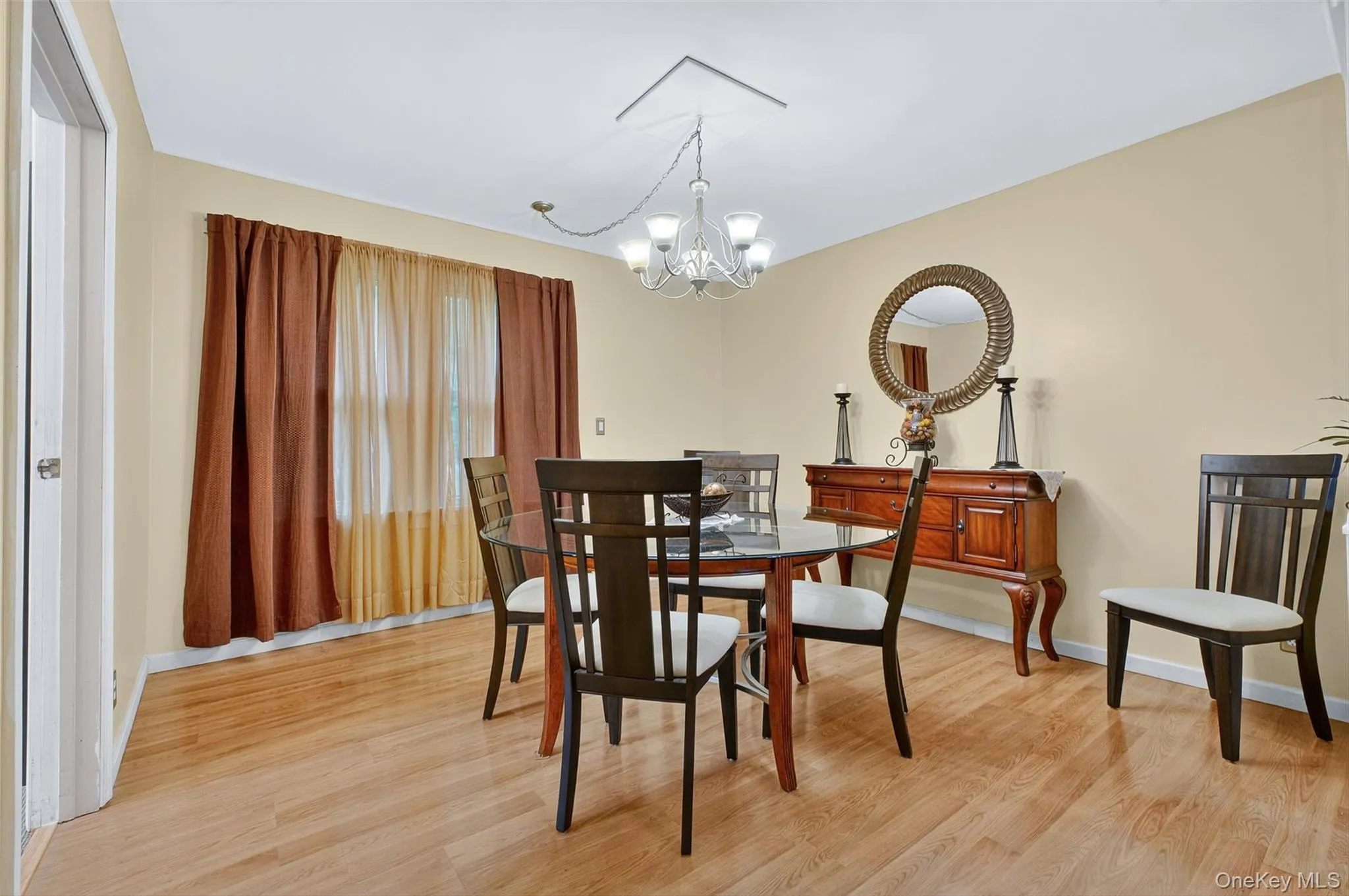 Dining space with light wood-type flooring and a chandelier Dining space with light wood-type flooring and a chandelier