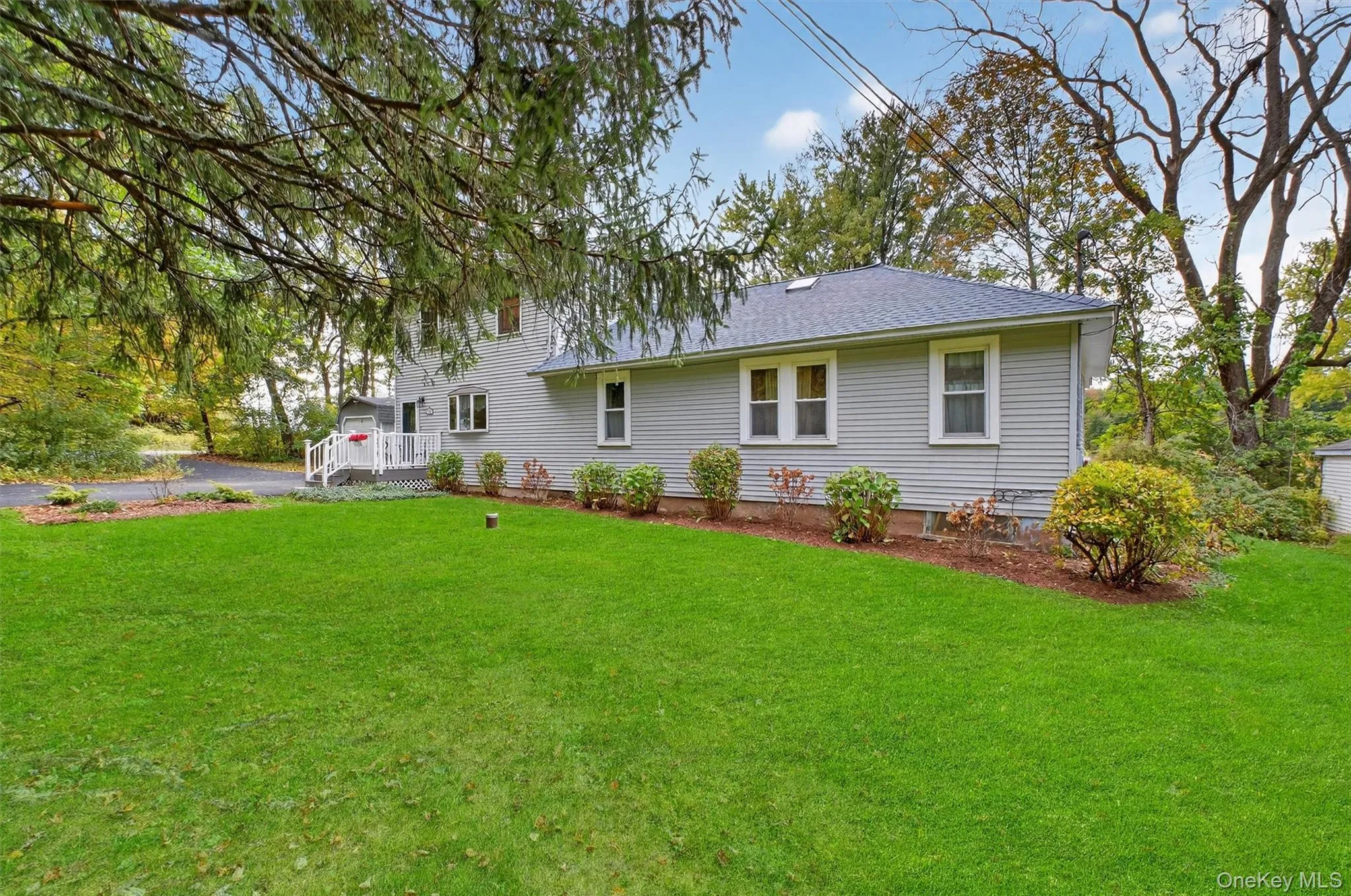 Rear view of house featuring a lawn and a shingled roof Rear view of house featuring a lawn and a shingled roof