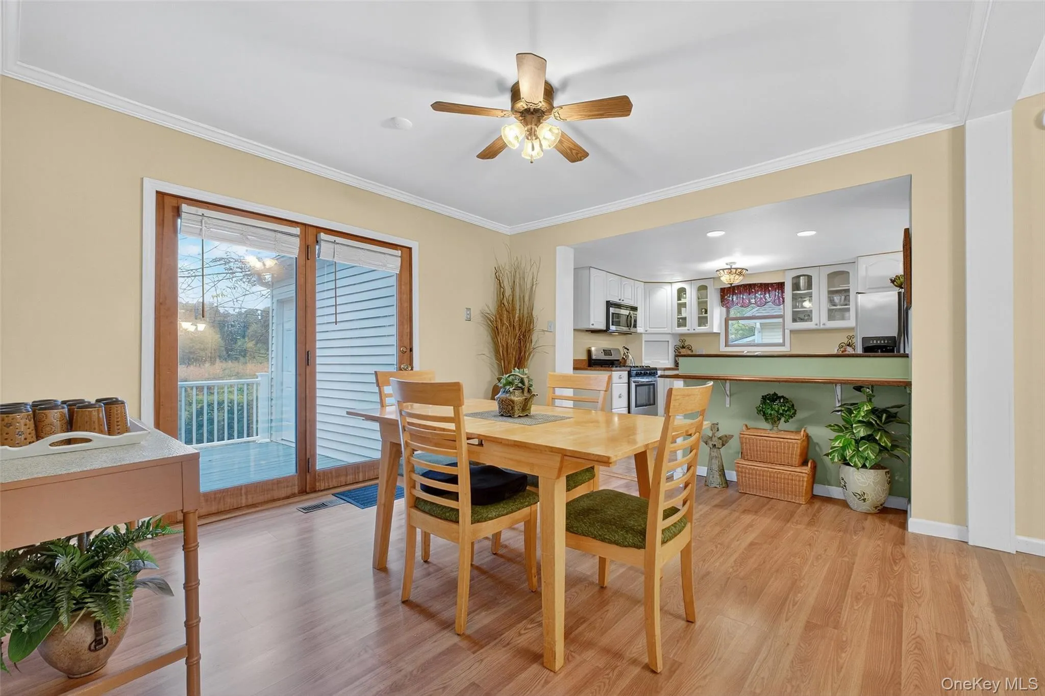 Dining space with light wood-style floors, ornamental molding, and a ceiling fan Dining space with light wood-style floors, ornamental molding, and a ceiling fan