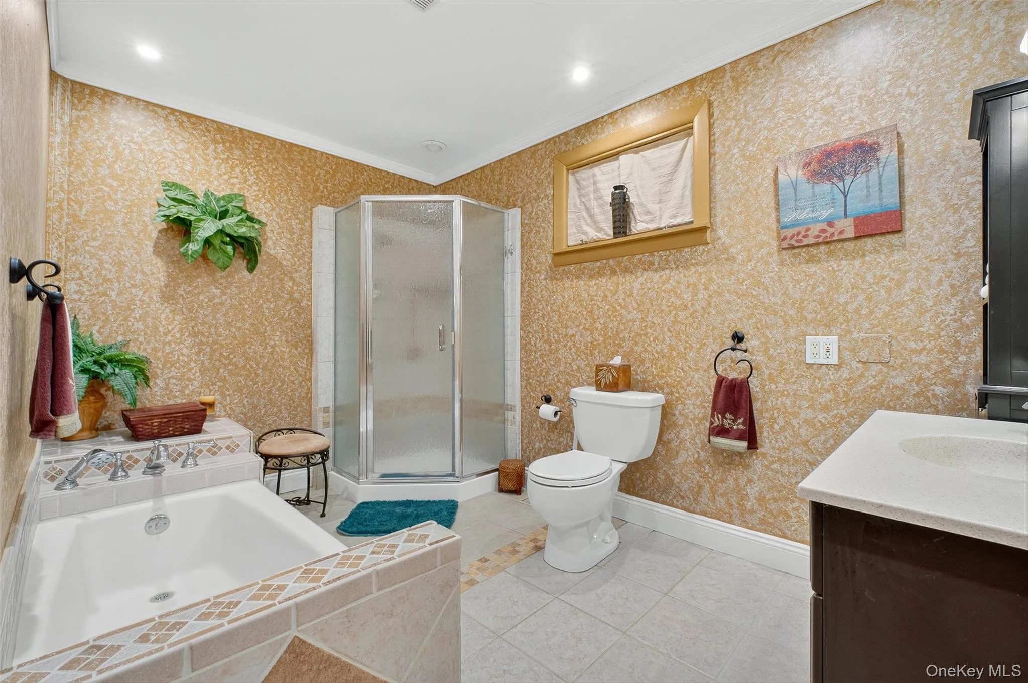 Bathroom featuring ornamental molding, vanity, a stall shower, light tile patterned flooring, and a garden tub Bathroom featuring ornamental molding, vanity, a stall shower, light tile patterned flooring, and a garden tub