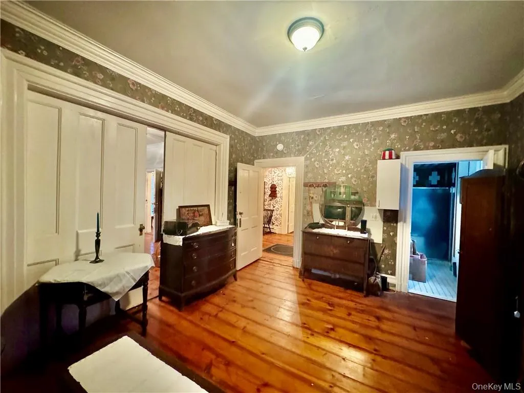 1st floor Bedroom featuring ornamental molding and wood-type flooring 1st floor Bedroom featuring ornamental molding and wood-type flooring