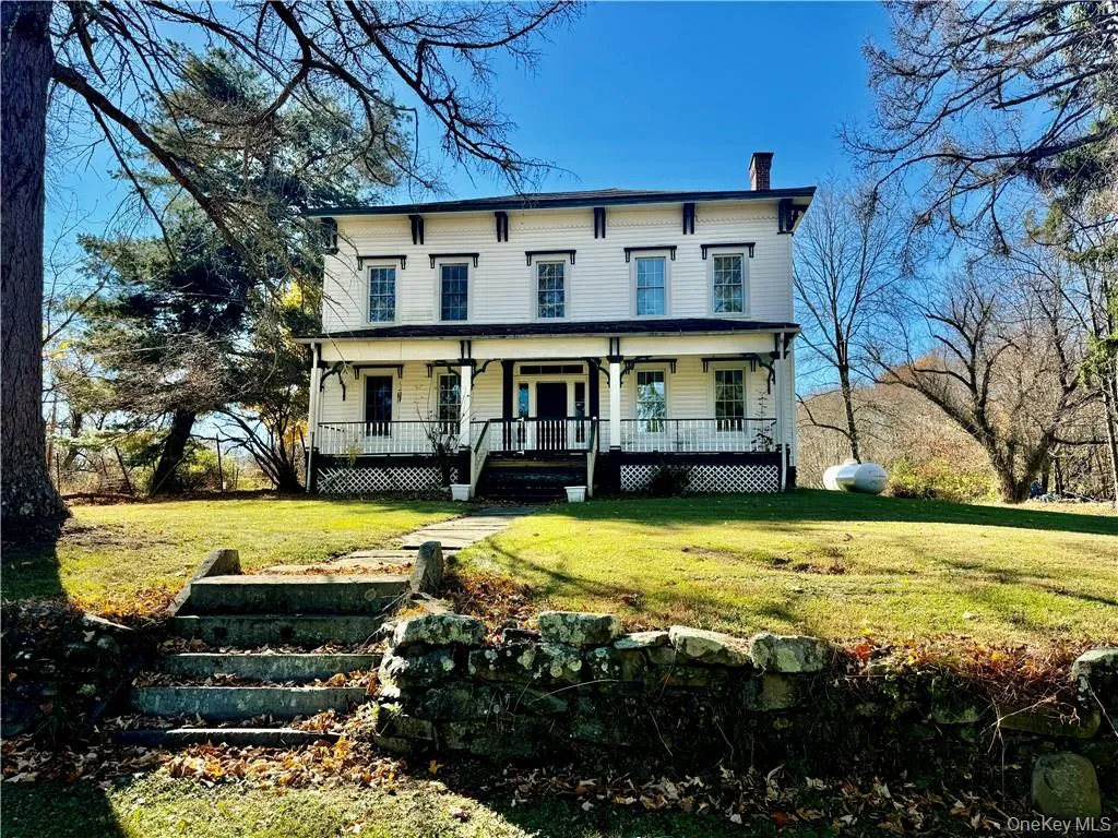 Italianate house featuring a porch and a front lawn Italianate house featuring a porch and a front lawn
