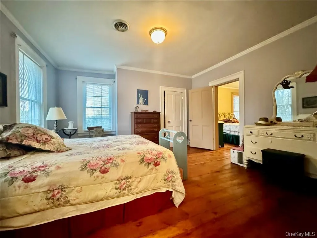 Bedroom with crown molding and hardwood / wood-style floors Bedroom with crown molding and hardwood / wood-style floors