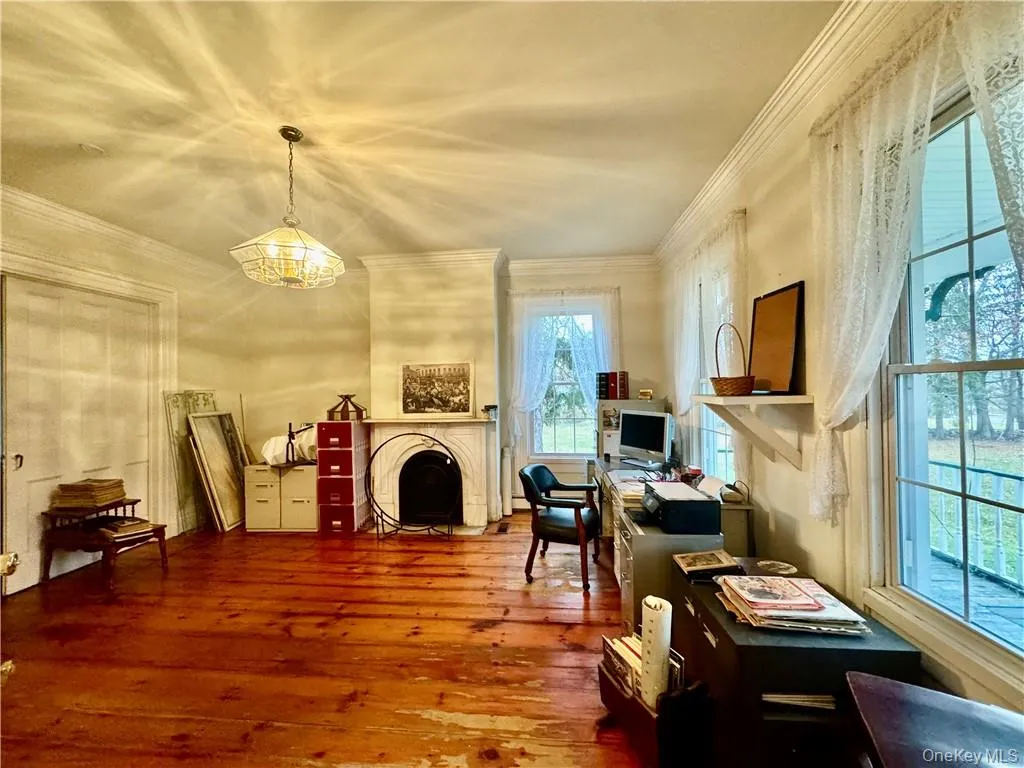 Home office featuring crown molding, a healthy amount of sunlight, wood-type flooring, and a chandelier Home office featuring crown molding, a healthy amount of sunlight, wood-type flooring, and a chandelier