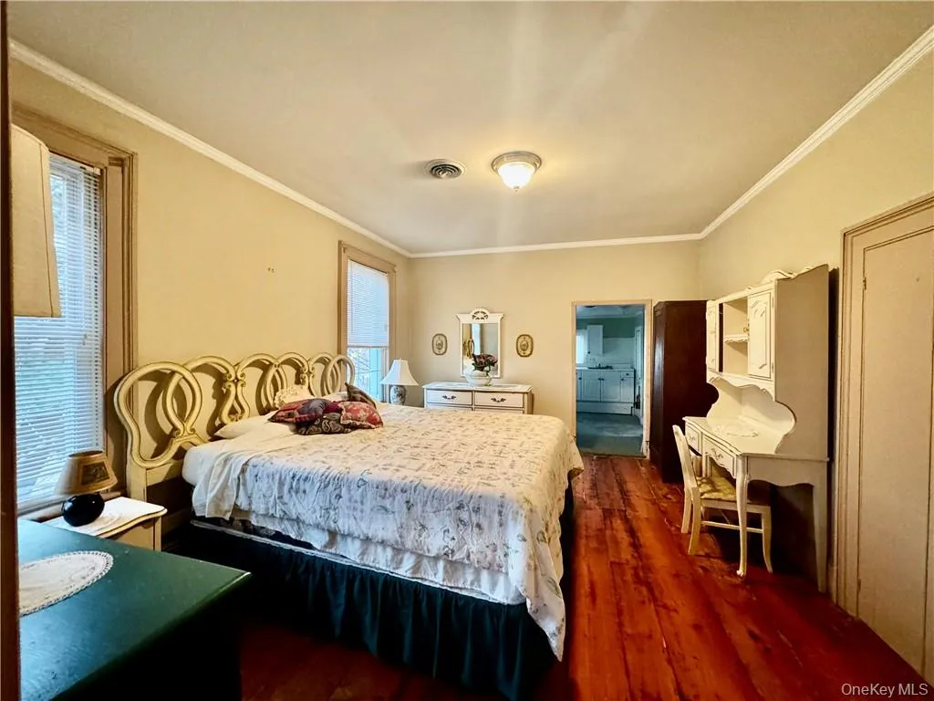 Bedroom with ornamental molding and dark hardwood / wood-style flooring Bedroom with ornamental molding and dark hardwood / wood-style flooring