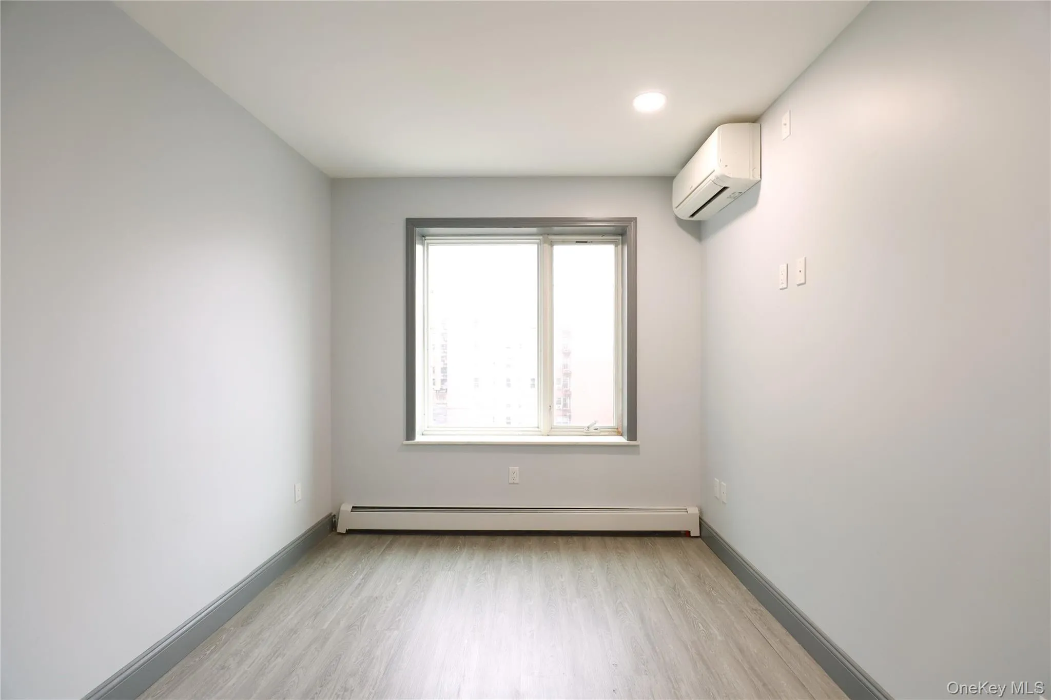 Bedroom with light wood-type flooring, a baseboard heating unit, and recessed lighting Bedroom with light wood-type flooring, a baseboard heating unit, and recessed lighting