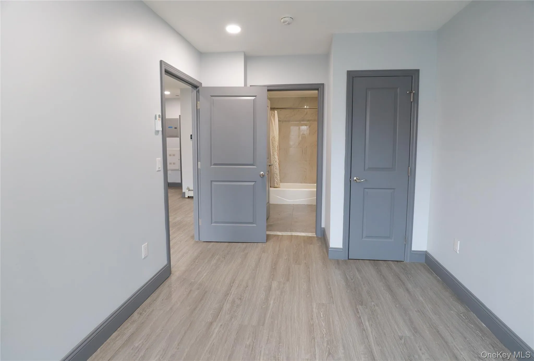 Bedroom with light wood finished floors and ensuite bath Bedroom with light wood finished floors and ensuite bath