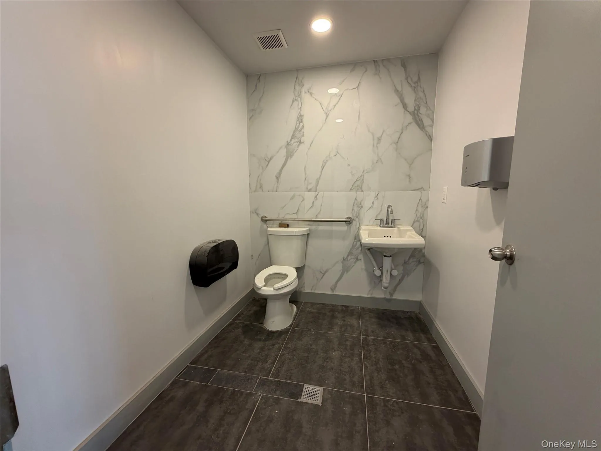 Bathroom featuring recessed lighting and dark tile patterned flooring Bathroom featuring recessed lighting and dark tile patterned flooring