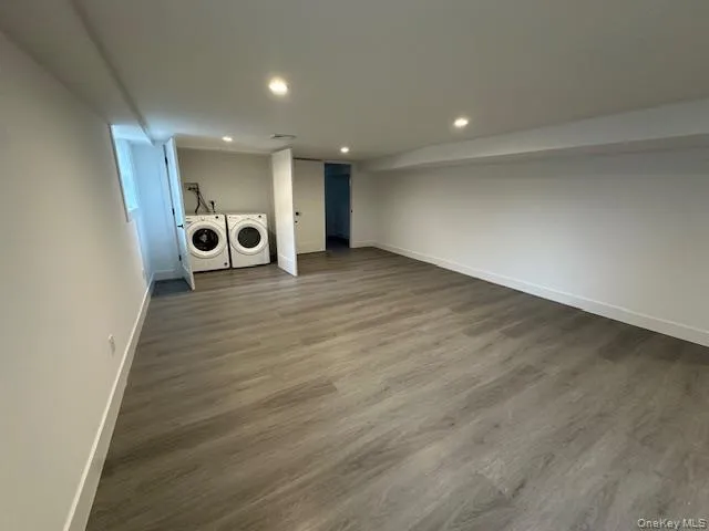 Finished basement with dark wood-type flooring, washer and clothes dryer, and recessed lighting Finished basement with dark wood-type flooring, washer and clothes dryer, and recessed lighting