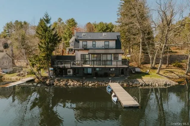 The property features a multi-level design with a metal roof and a spacious deck overlooking the water The property features a multi-level design with a metal roof and a spacious deck overlooking the water