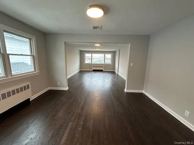 Dining room with dark wood-type flooring and radiator heating unit Dining room with dark wood-type flooring and radiator heating unit