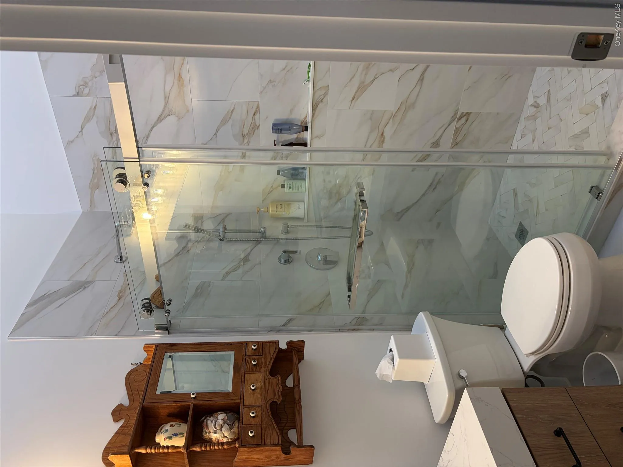 Bathroom with vanity and a marble finish shower Bathroom with vanity and a marble finish shower