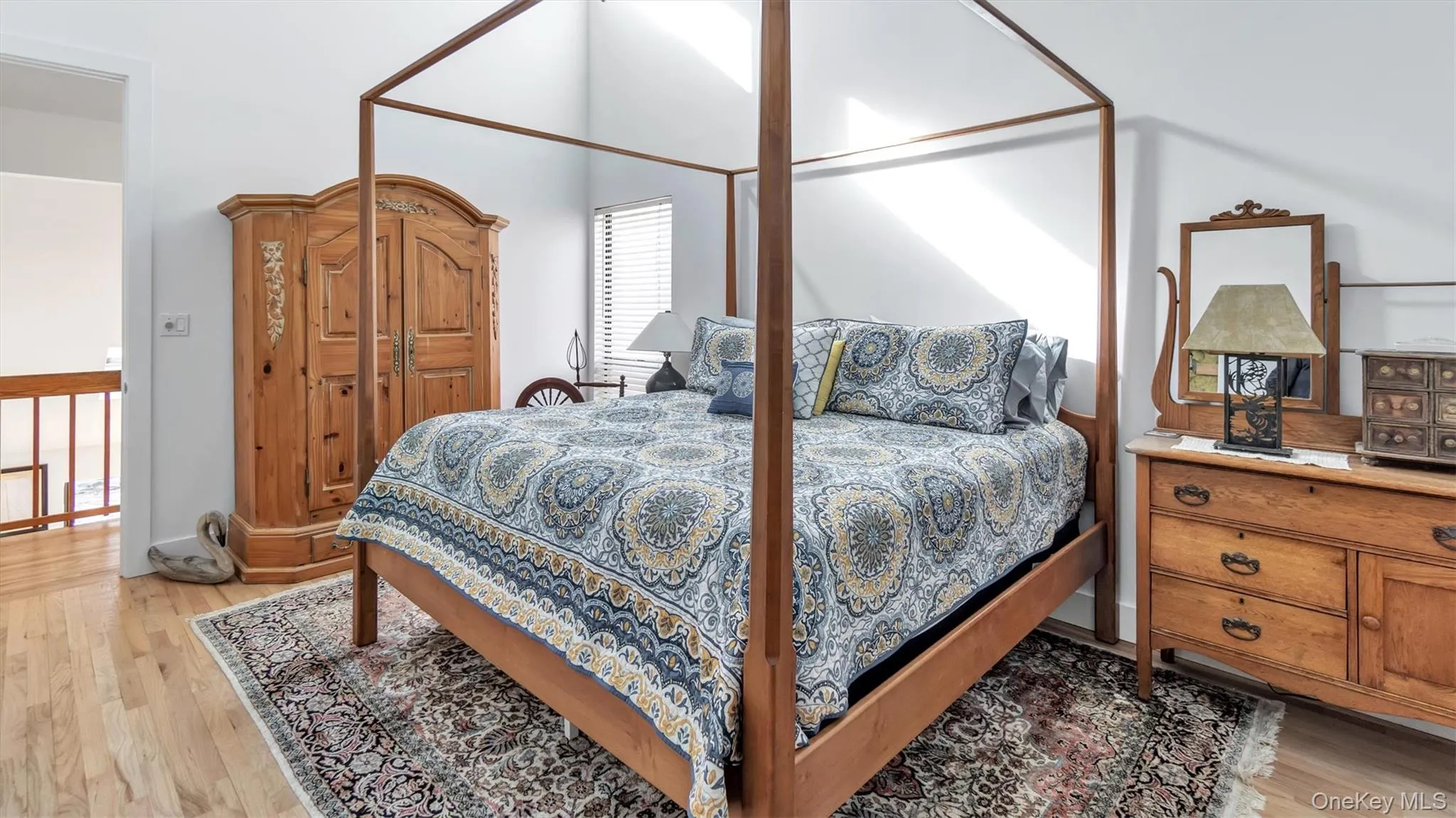 Bedroom featuring light wood-style floors and a high ceiling Bedroom featuring light wood-style floors and a high ceiling