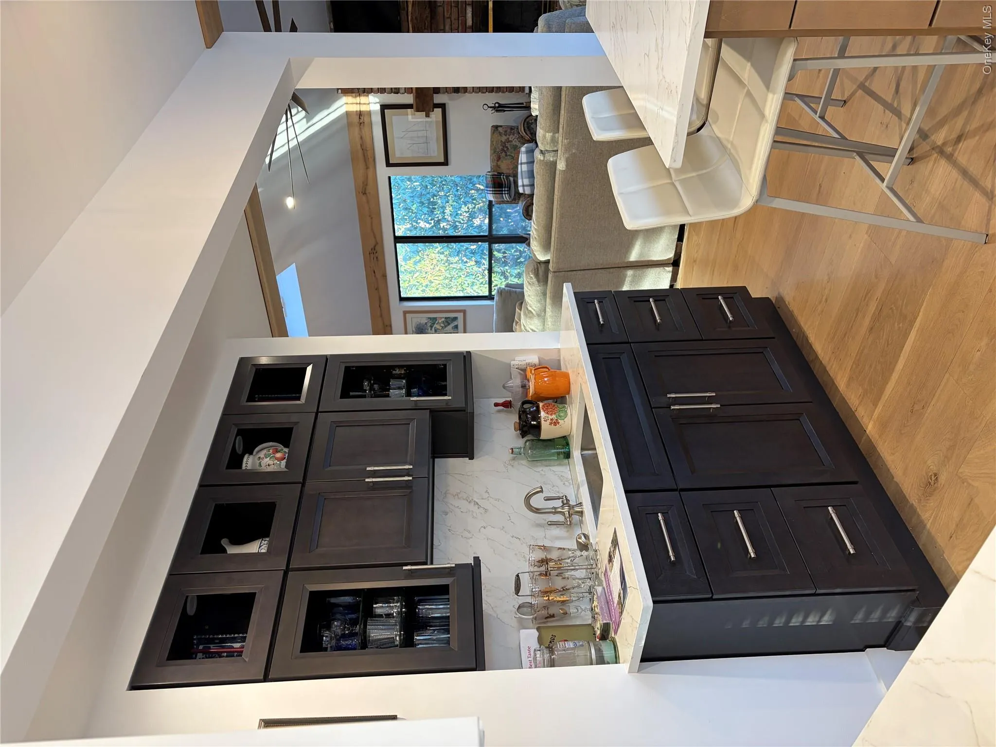 Kitchen featuring glass insert cabinets, light stone countertops, backsplash, open floor plan, and recessed lighting Kitchen featuring glass insert cabinets, light stone countertops, backsplash, open floor plan, and recessed lighting
