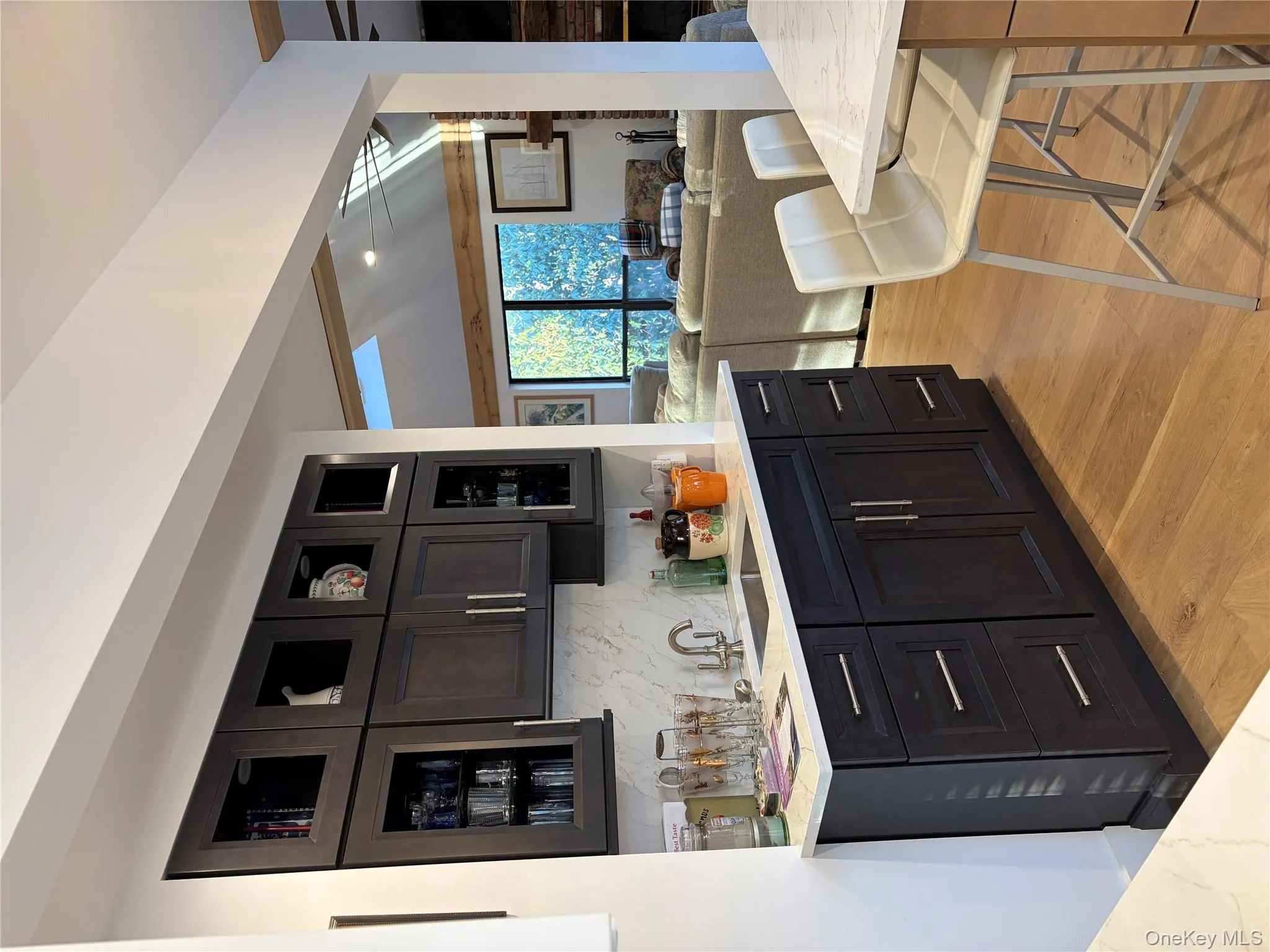 Kitchen featuring glass insert cabinets, light stone countertops, backsplash, open floor plan, and recessed lighting Kitchen featuring glass insert cabinets, light stone countertops, backsplash, open floor plan, and recessed lighting