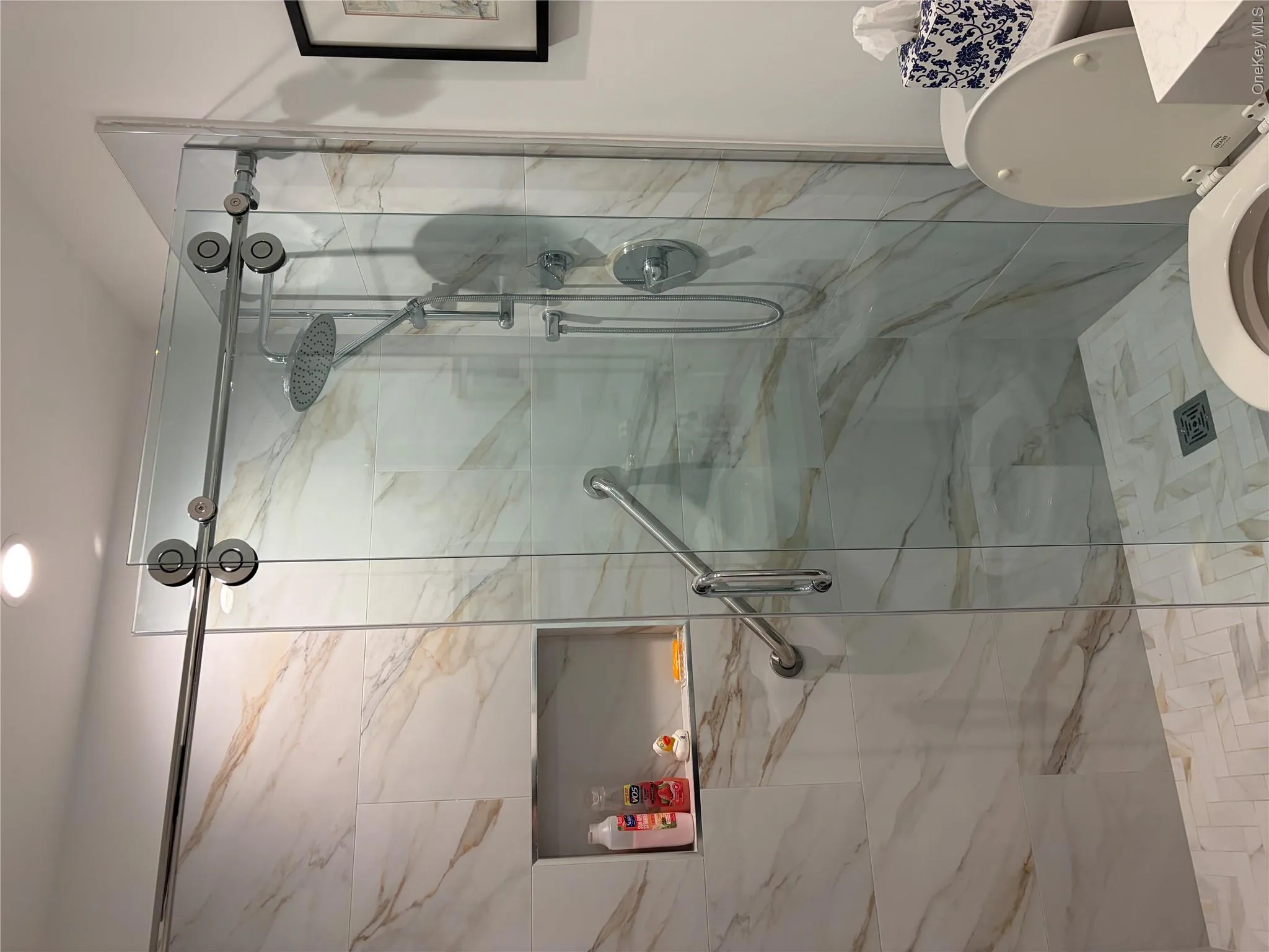 Full bathroom with a marble finish shower and toilet Full bathroom with a marble finish shower and toilet