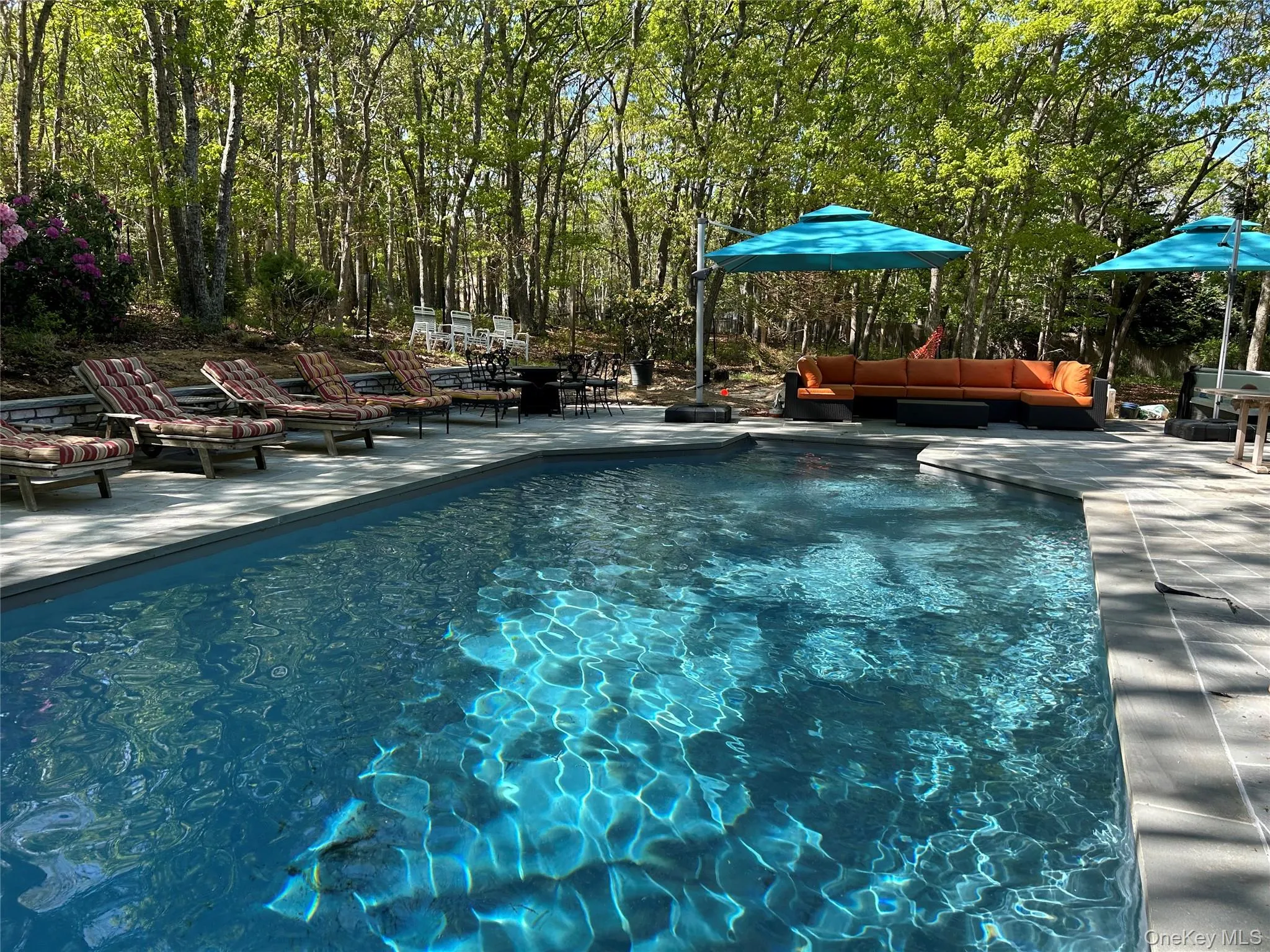 Outdoor pool with a patio and outdoor furniture Outdoor pool with a patio and outdoor furniture