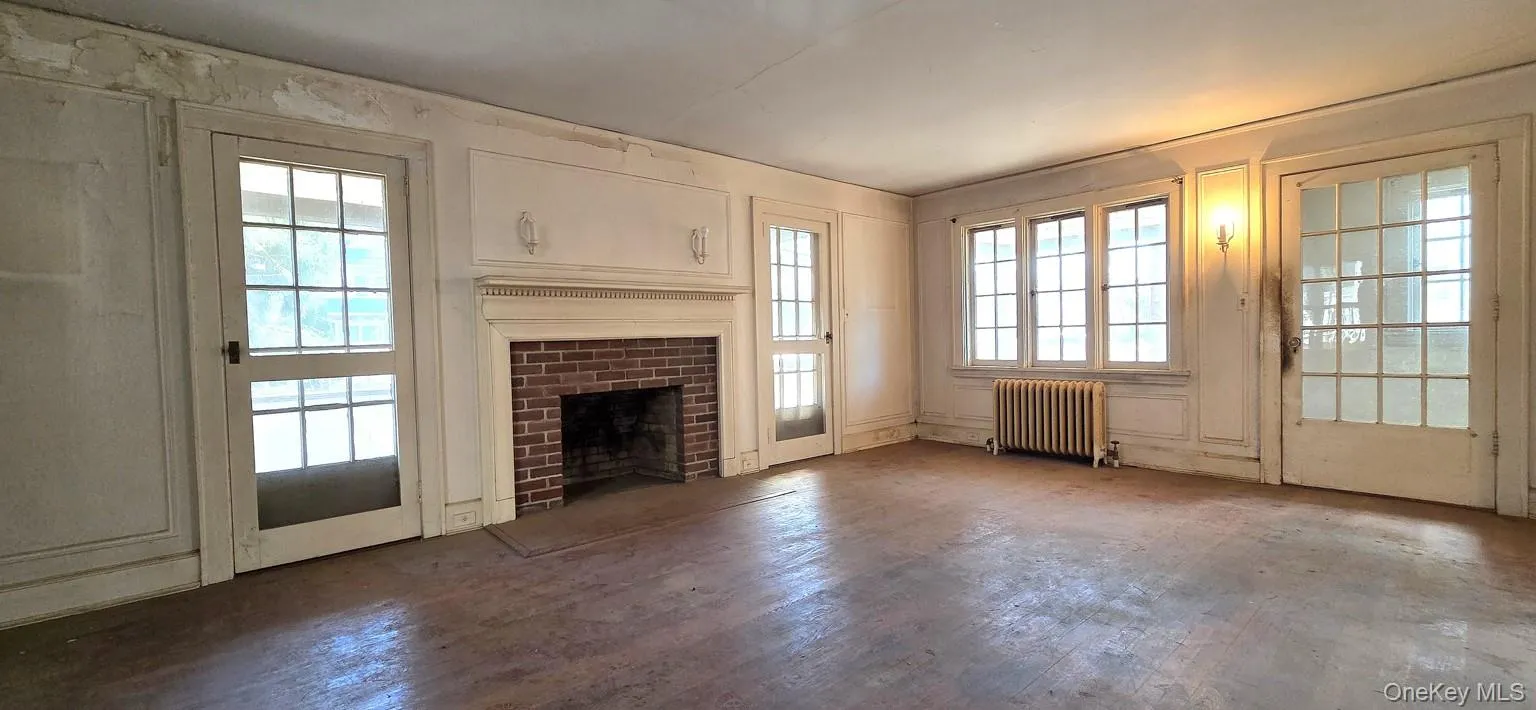 Living room has wood-burning fireplace and doors to front porch Living room has wood-burning fireplace and doors to front porch