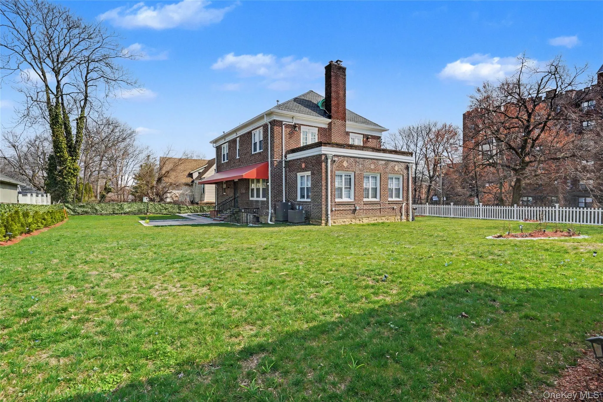 Back of house featuring brick siding and a chimney Back of house featuring brick siding and a chimney