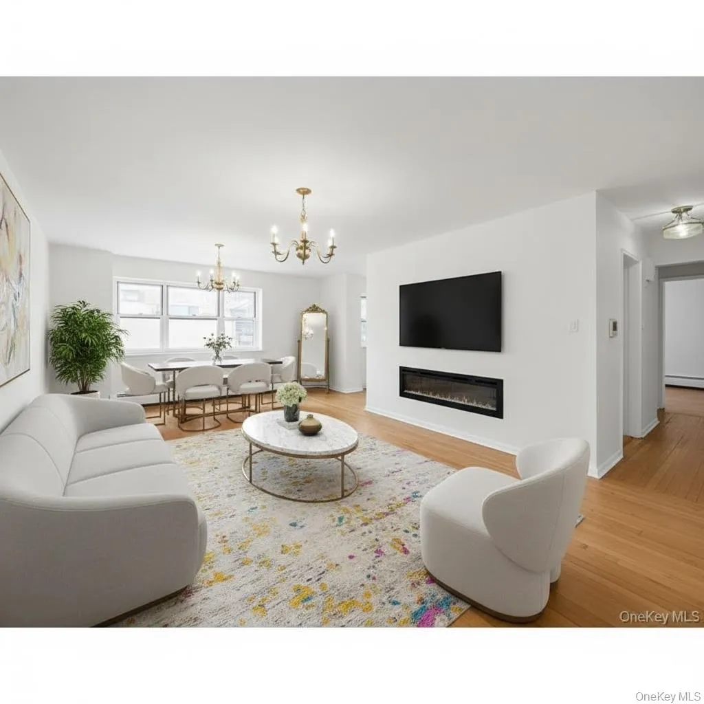 Living area with light wood-style floors, a glass covered fireplace, suspended lighting, and a baseboard heating unit. Digitally staged. Living area with light wood-style floors, a glass covered fireplace, suspended lighting, and a baseboard heating unit. Digitally staged.