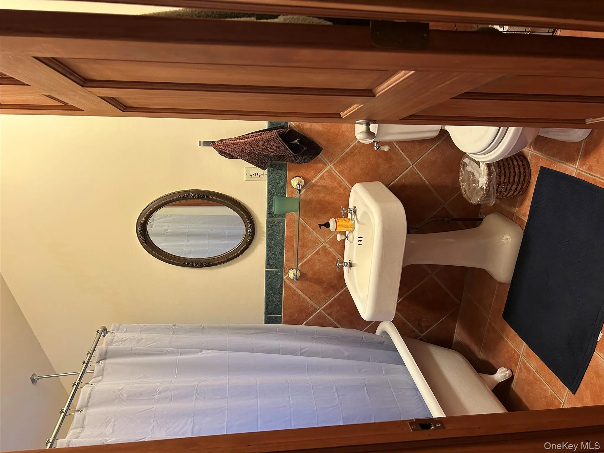 Bathroom with toilet, tile patterned flooring, and tile walls Bathroom with toilet, tile patterned flooring, and tile walls