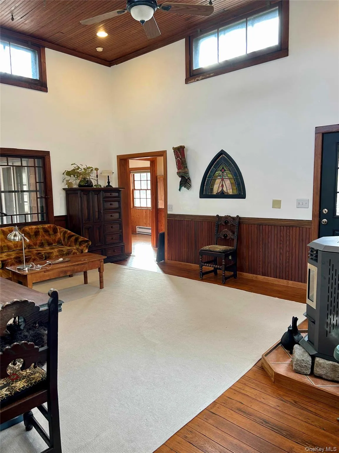 Carpeted living room with a towering ceiling, pellet stove Carpeted living room with a towering ceiling, pellet stove