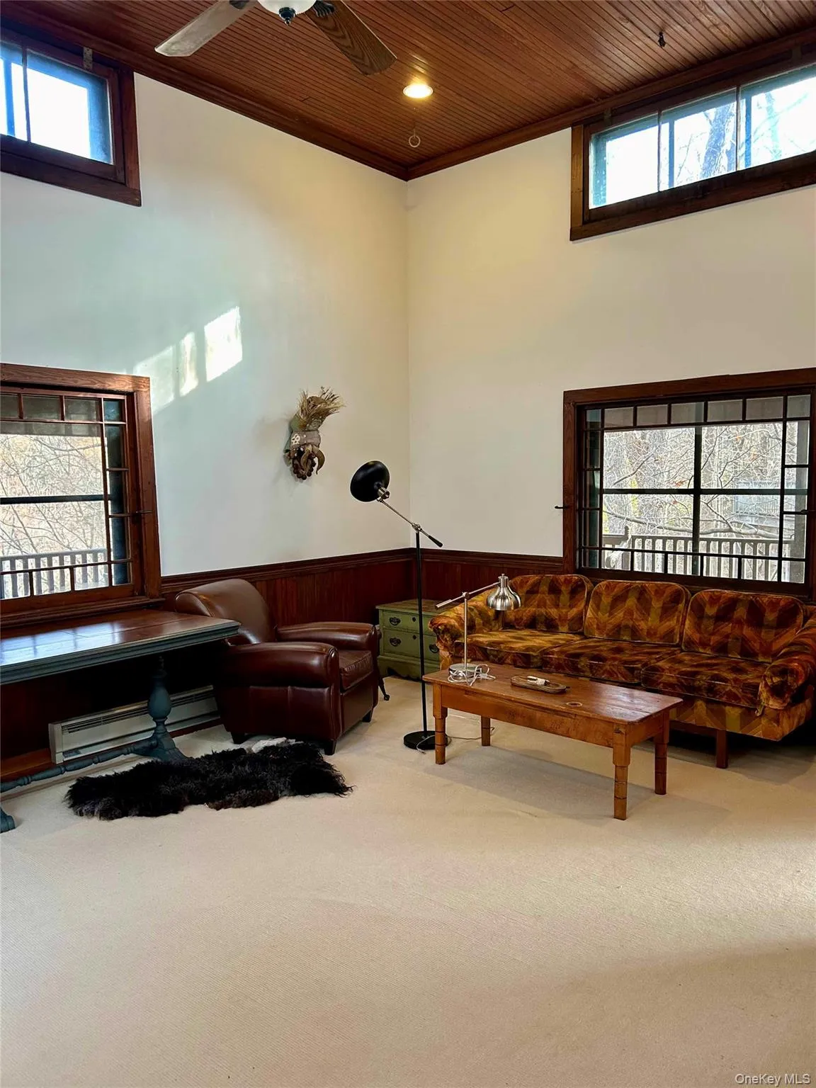 Carpeted living room with wood ceiling, crown molding, pellet stove Carpeted living room with wood ceiling, crown molding, pellet stove