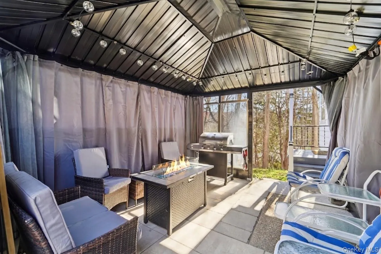 Covered patio with seating and fire table. Covered patio with seating and fire table.