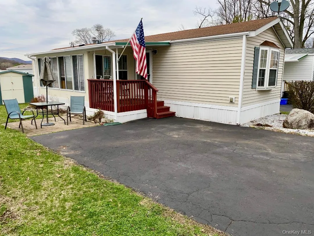 Very appealing ranch style manufactured home featuring a patio area, deck and driveway area Very appealing ranch style manufactured home featuring a patio area, deck and driveway area