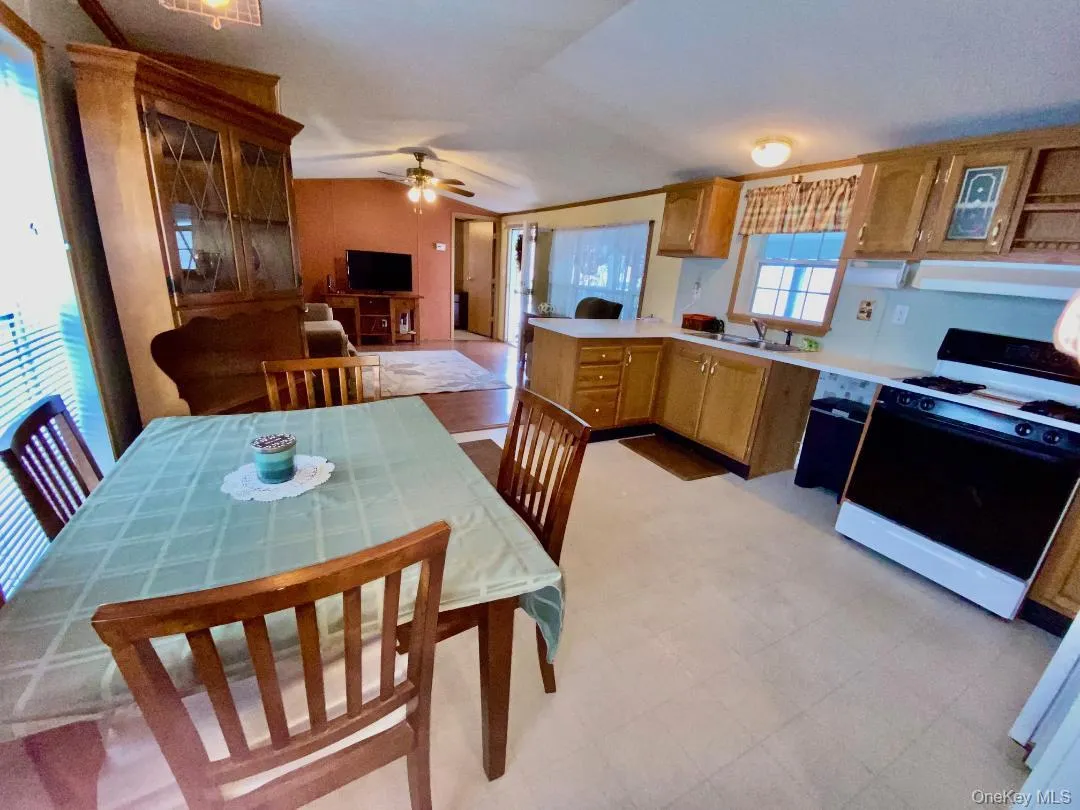 Kitchen with gas range oven, a peninsula, light countertops, lofted ceiling, and ventilation hood Kitchen with gas range oven, a peninsula, light countertops, lofted ceiling, and ventilation hood