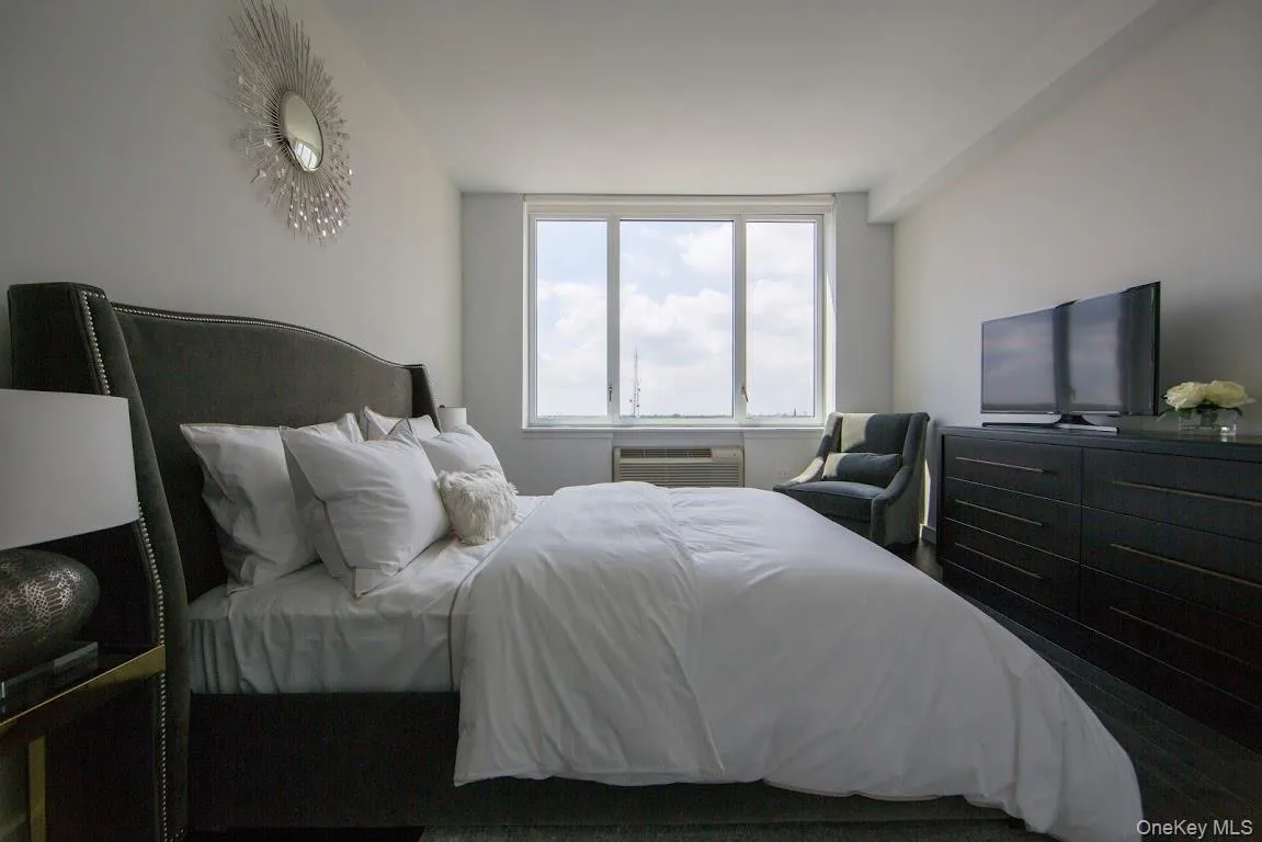 Bedroom with a wall mounted AC and wood finished floors Bedroom with a wall mounted AC and wood finished floors