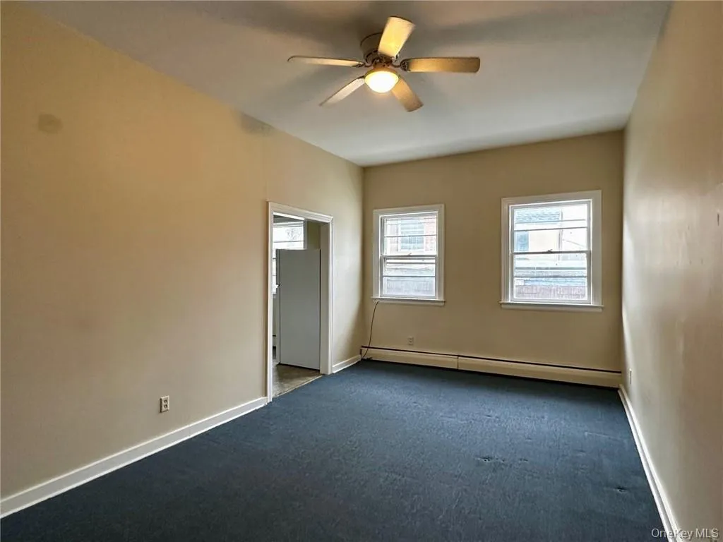 Unfurnished room with ceiling fan, baseboard heating, and carpet floors Unfurnished room with ceiling fan, baseboard heating, and carpet floors
