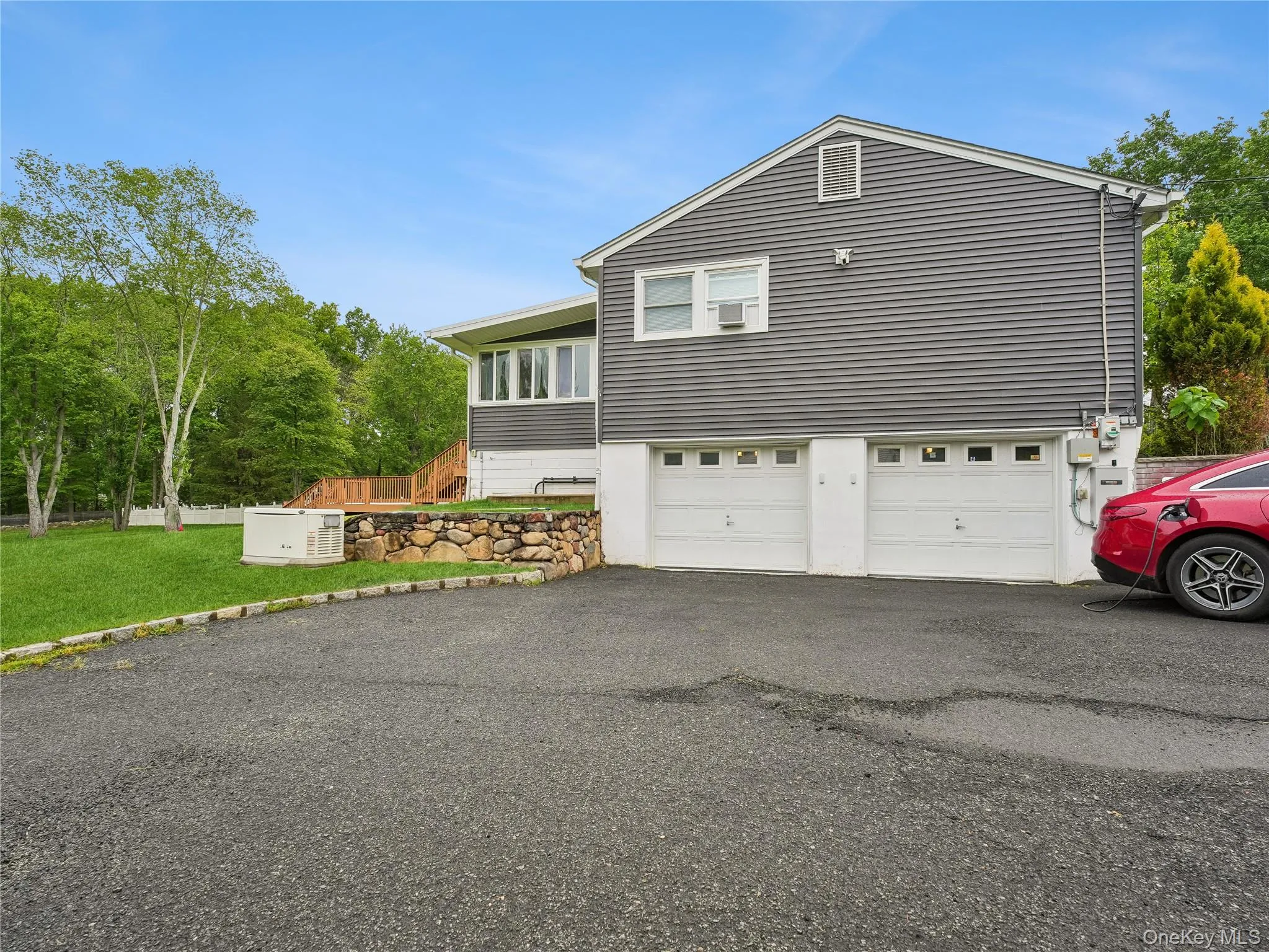Exterior featuring grey horizontal siding, two white garage doors. Exterior featuring grey horizontal siding, two white garage doors.