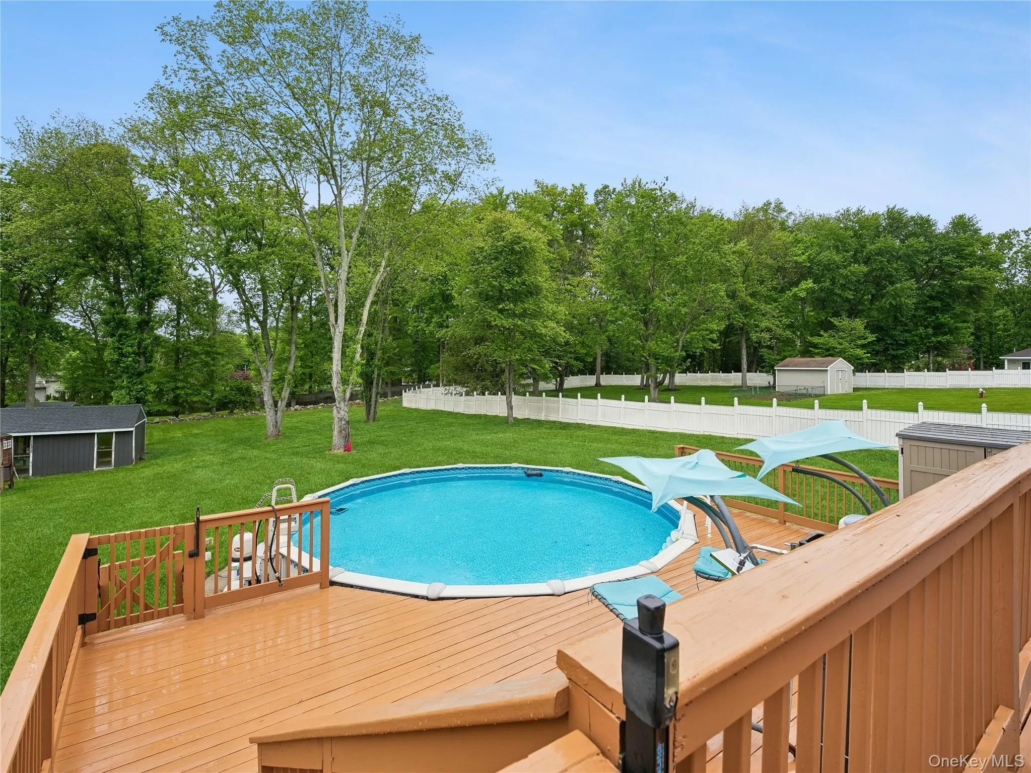 Expansive backyard featuring a large above-ground pool, surrounding wood-finish deck. Expansive backyard featuring a large above-ground pool, surrounding wood-finish deck.