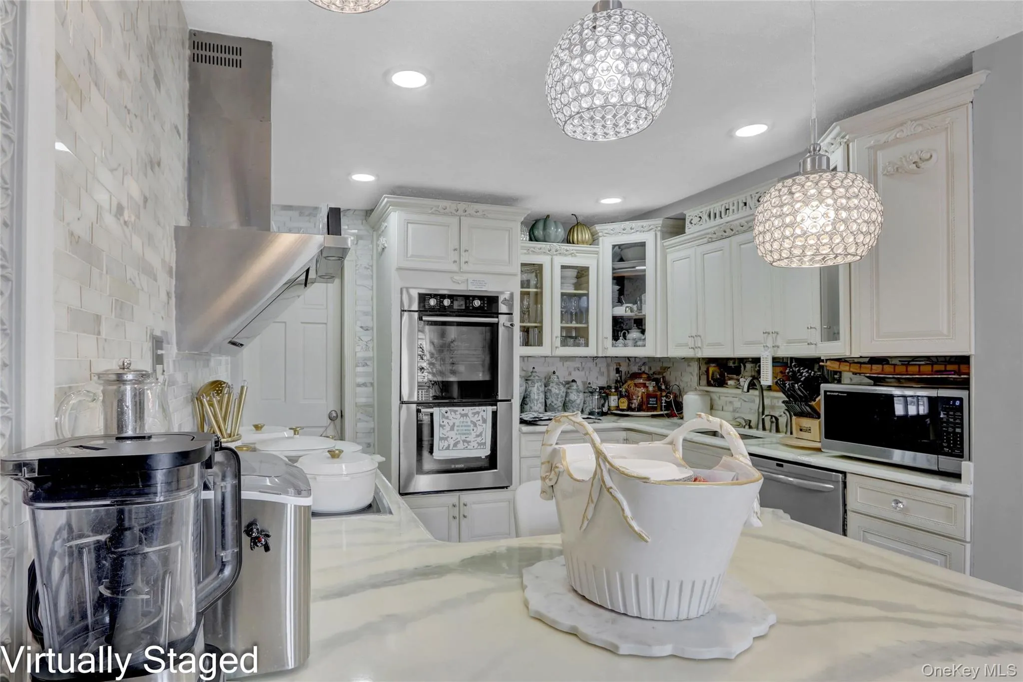 Kitchen with glass insert cabinets, white cabinets, stainless steel appliances, and light stone counters Kitchen with glass insert cabinets, white cabinets, stainless steel appliances, and light stone counters