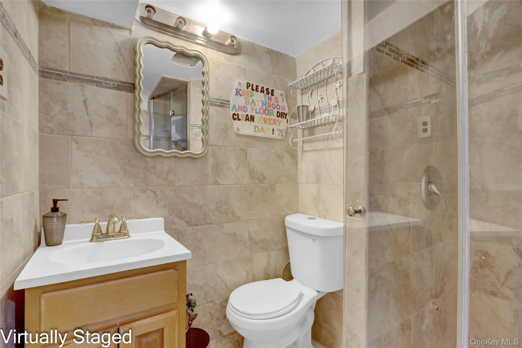 Bathroom featuring vanity, a shower stall, and tile walls Bathroom featuring vanity, a shower stall, and tile walls