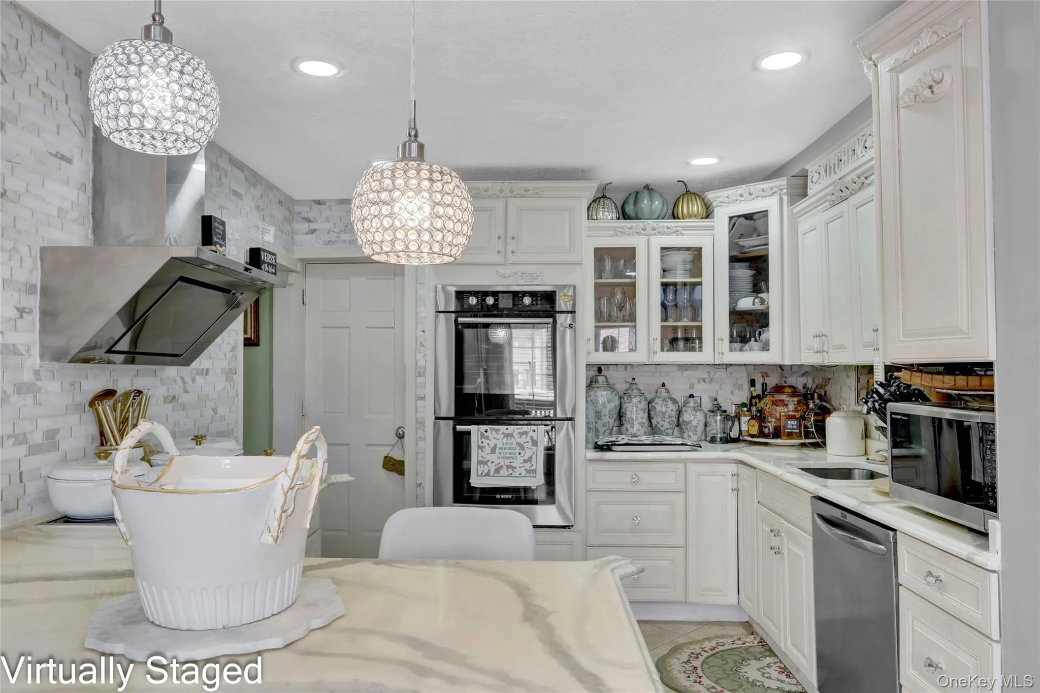 Kitchen with stainless steel appliances, glass insert cabinets, white cabinets, light stone countertops, and tasteful backsplash Kitchen with stainless steel appliances, glass insert cabinets, white cabinets, light stone countertops, and tasteful backsplash