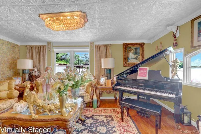 Sitting room featuring an ornate ceiling, wood finished floors, and ornamental molding Sitting room featuring an ornate ceiling, wood finished floors, and ornamental molding