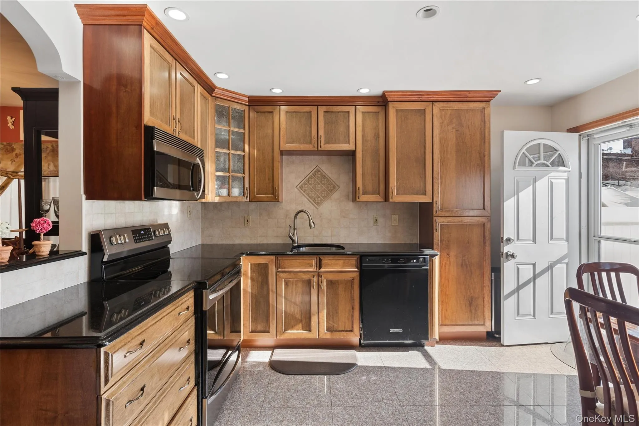 The kitchen is thoughtfully appointed with custom-made cabinetry, a convenient pull-out pots and pans shelves and sleek granite countertops and flooring, combining functionality with style The kitchen is thoughtfully appointed with custom-made cabinetry, a convenient pull-out pots and pans shelves and sleek granite countertops and flooring, combining functionality with style