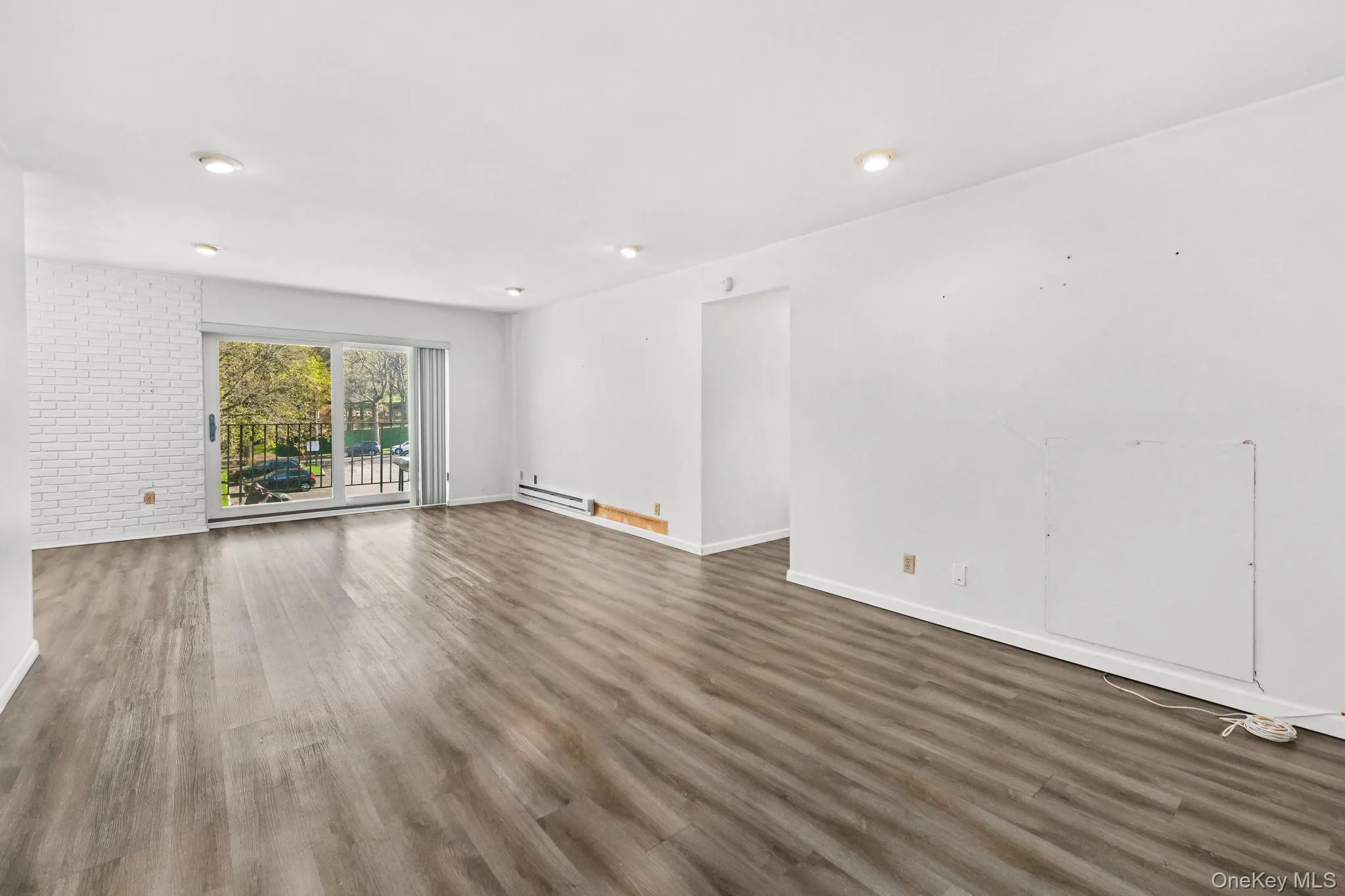 Spacious living area featuring plank flooring and recessed lighting Spacious living area featuring plank flooring and recessed lighting