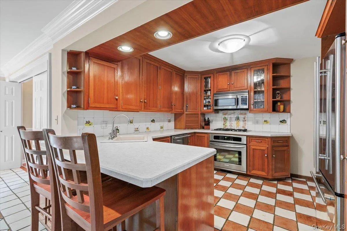 Open concept kitchen with solid cherry wood cabinets and stainless steel appliances. Open concept kitchen with solid cherry wood cabinets and stainless steel appliances.