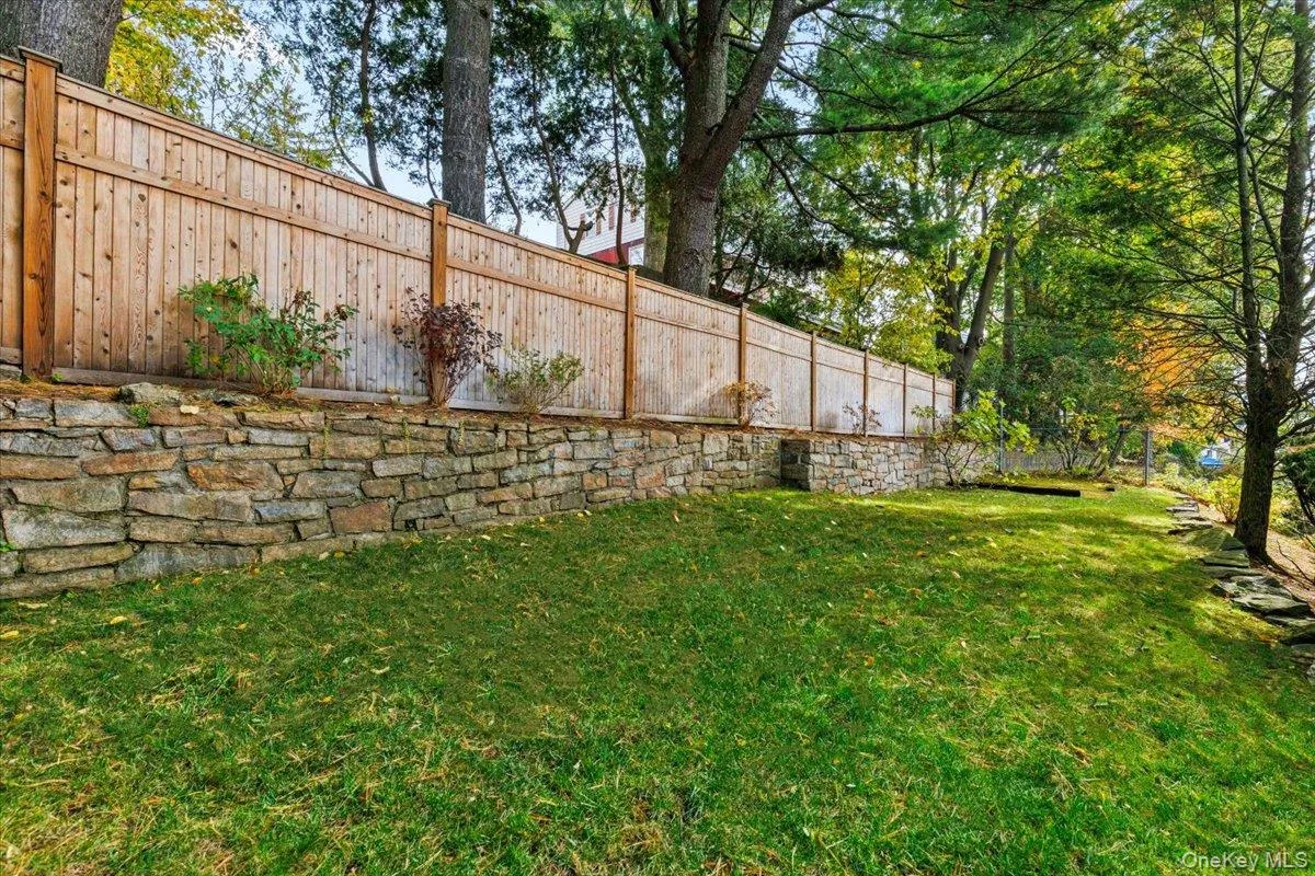 Stone retaining wall and fence provide privacy. Stone retaining wall and fence provide privacy.