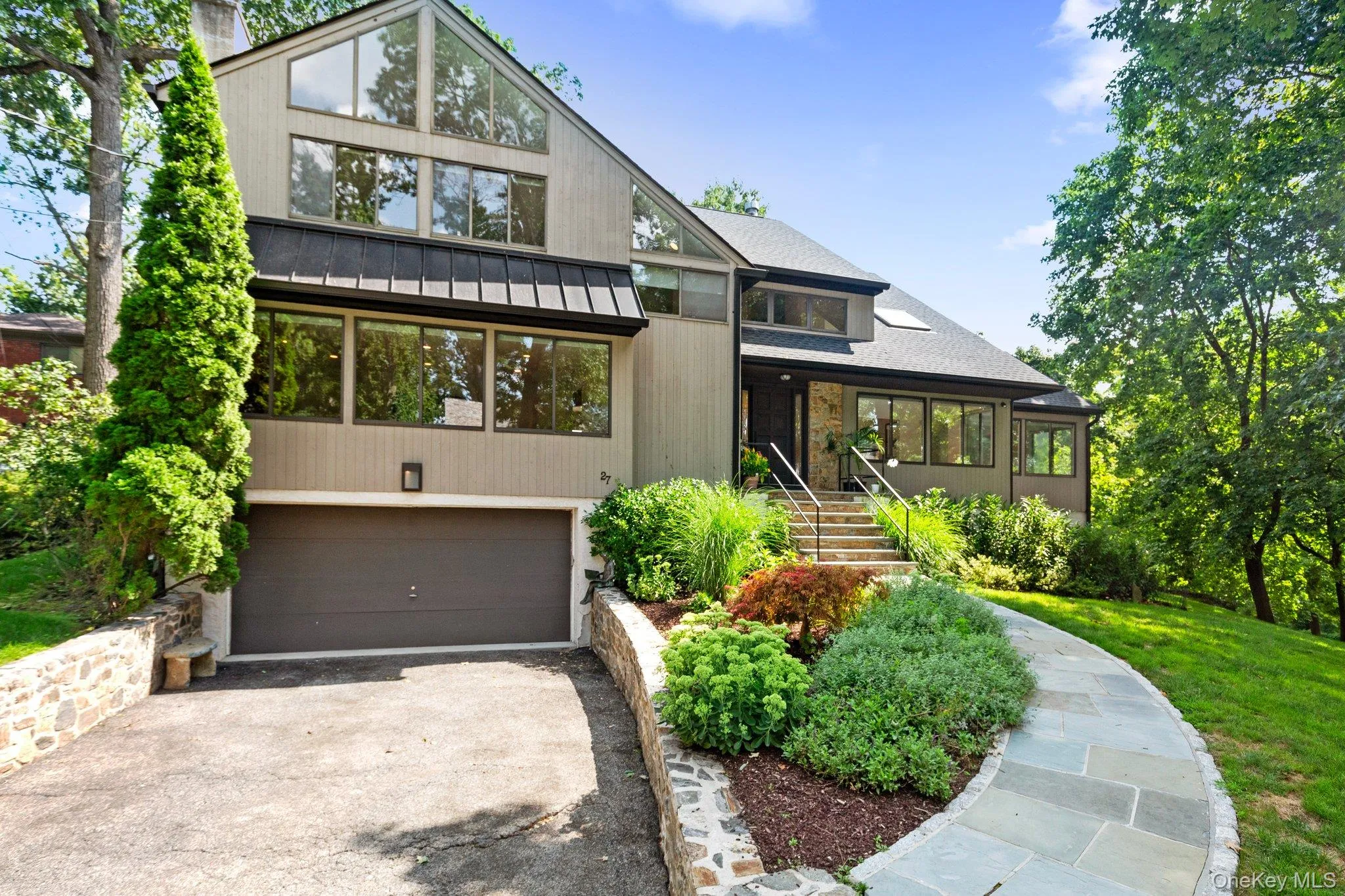 Mid-century inspired home featuring driveway and a garage Mid-century inspired home featuring driveway and a garage