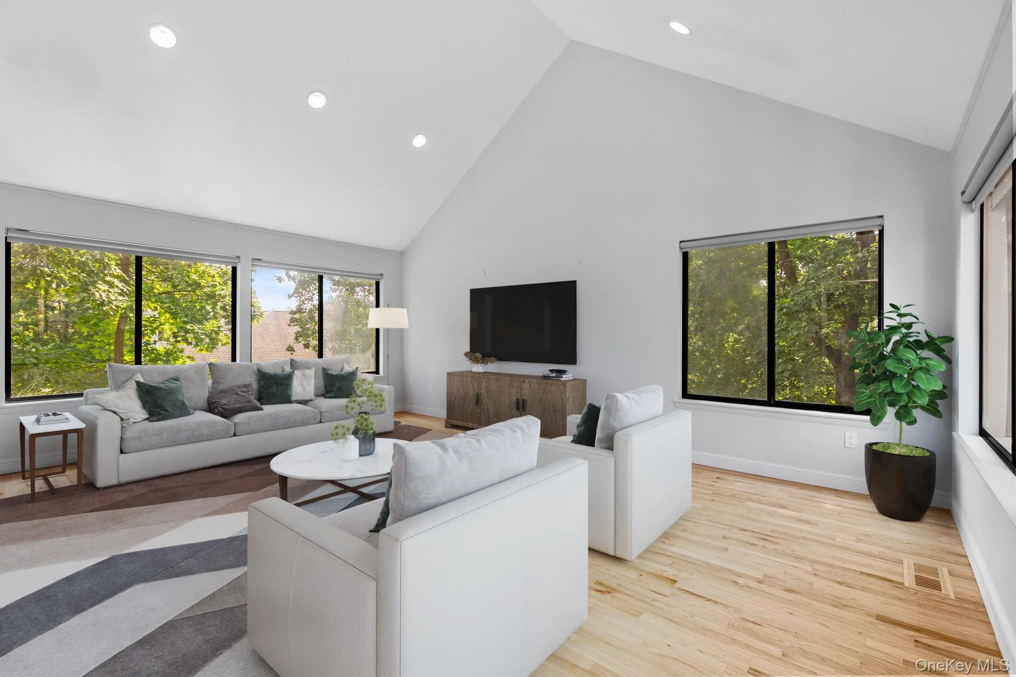 Living room featuring high vaulted ceiling, visible vents, baseboards, wood finished floors, and recessed lighting (virtually staged) Living room featuring high vaulted ceiling, visible vents, baseboards, wood finished floors, and recessed lighting (virtually staged)