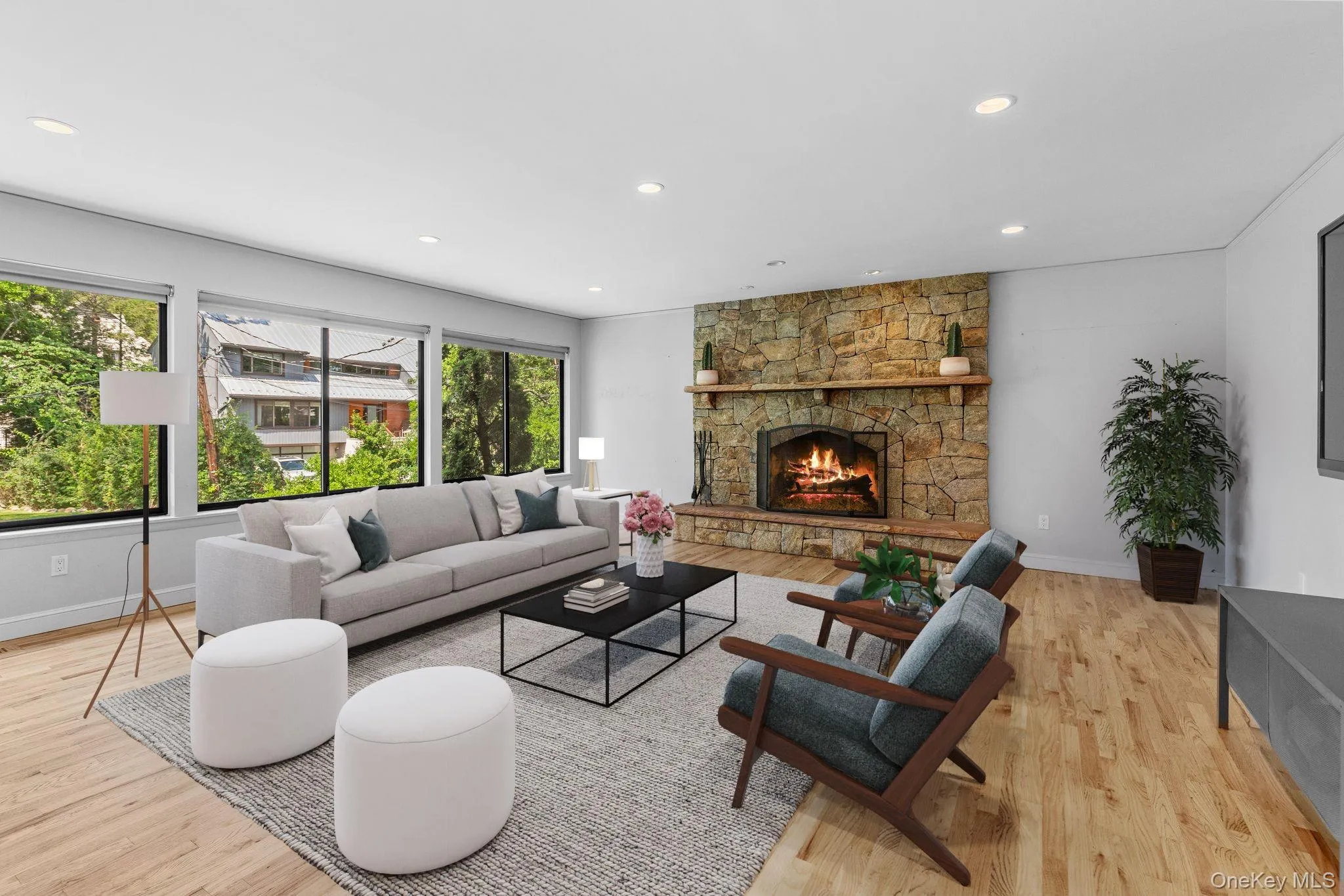 Living room with recessed lighting, light wood-style floors, and a stone fireplace (virtually staged) Living room with recessed lighting, light wood-style floors, and a stone fireplace (virtually staged)