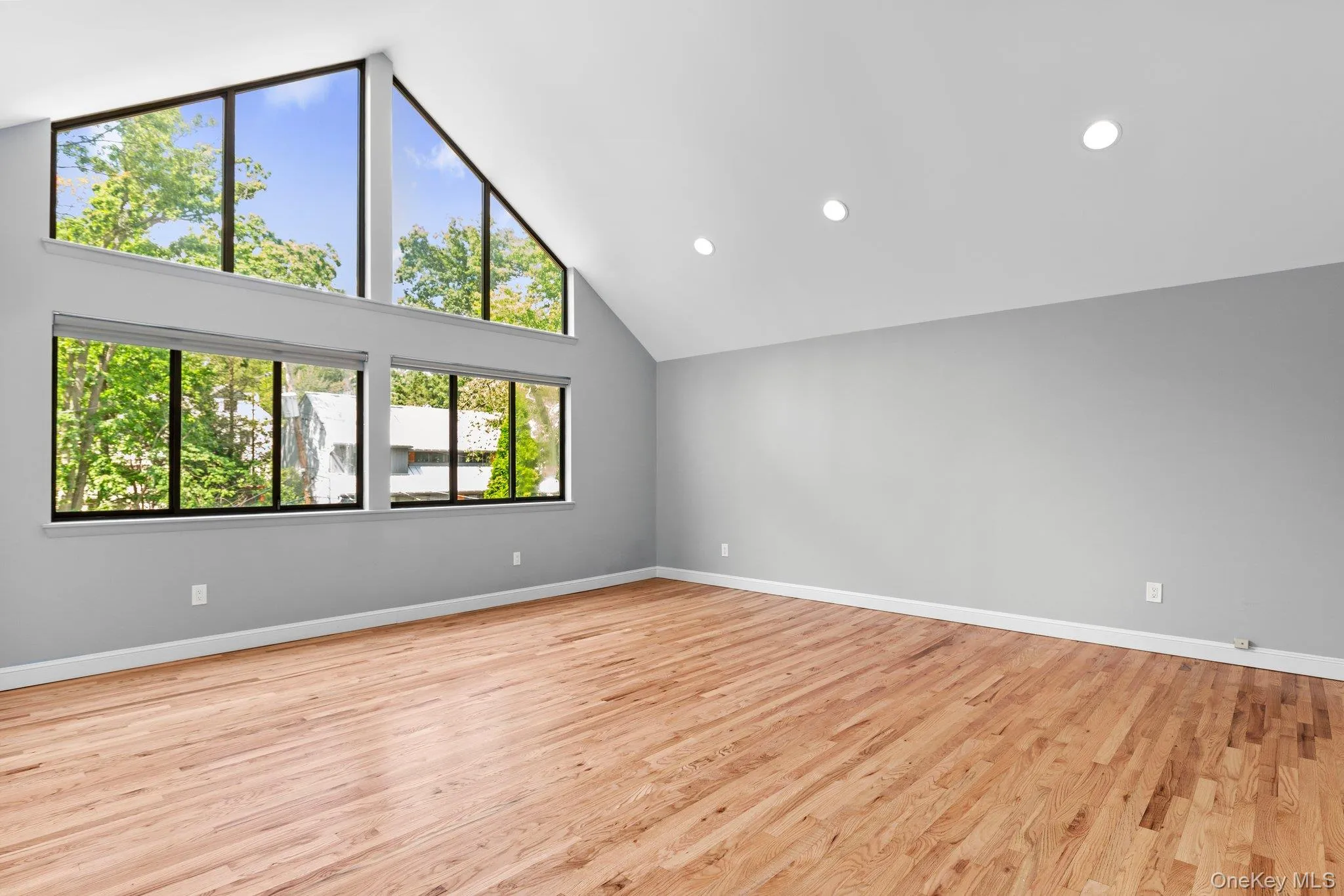 Bedroom featuring baseboards, light wood-type flooring, high vaulted ceiling, and recessed lighting Bedroom featuring baseboards, light wood-type flooring, high vaulted ceiling, and recessed lighting