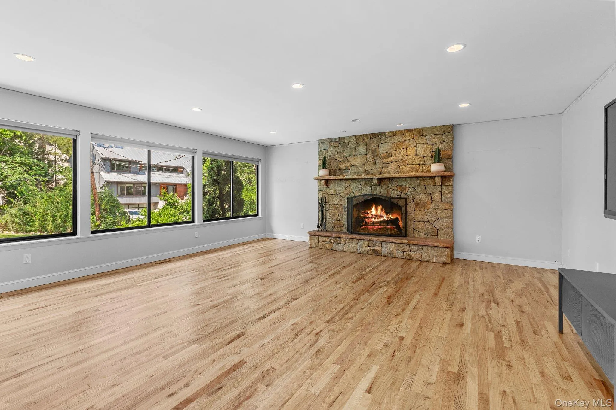Unfurnished living room featuring baseboards, a fireplace, light wood-style floors, and recessed lighting Unfurnished living room featuring baseboards, a fireplace, light wood-style floors, and recessed lighting