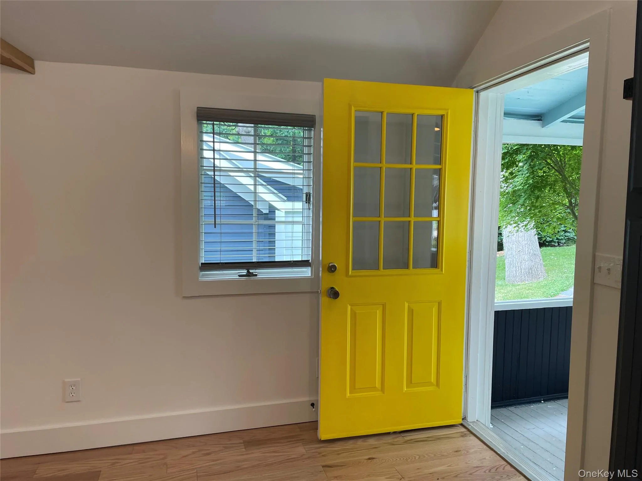 Doorway featuring wood finished floors, baseboards, and lofted ceiling Doorway featuring wood finished floors, baseboards, and lofted ceiling