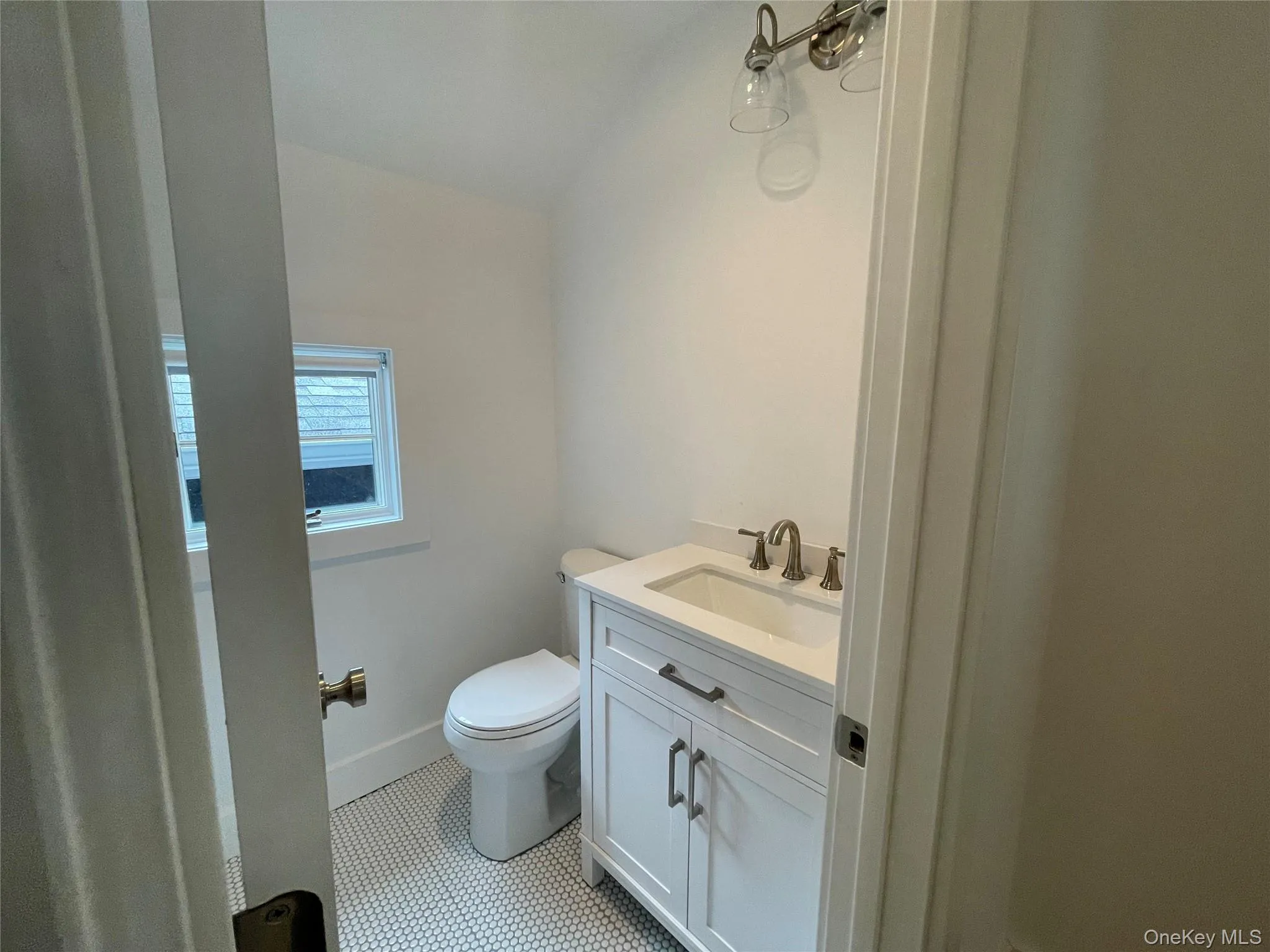 Half bath featuring toilet, vanity, tile patterned flooring, and baseboards Half bath featuring toilet, vanity, tile patterned flooring, and baseboards