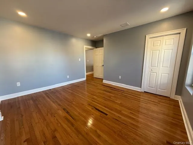 Unfurnished bedroom with recessed lighting, dark wood-style floors, and a closet Unfurnished bedroom with recessed lighting, dark wood-style floors, and a closet